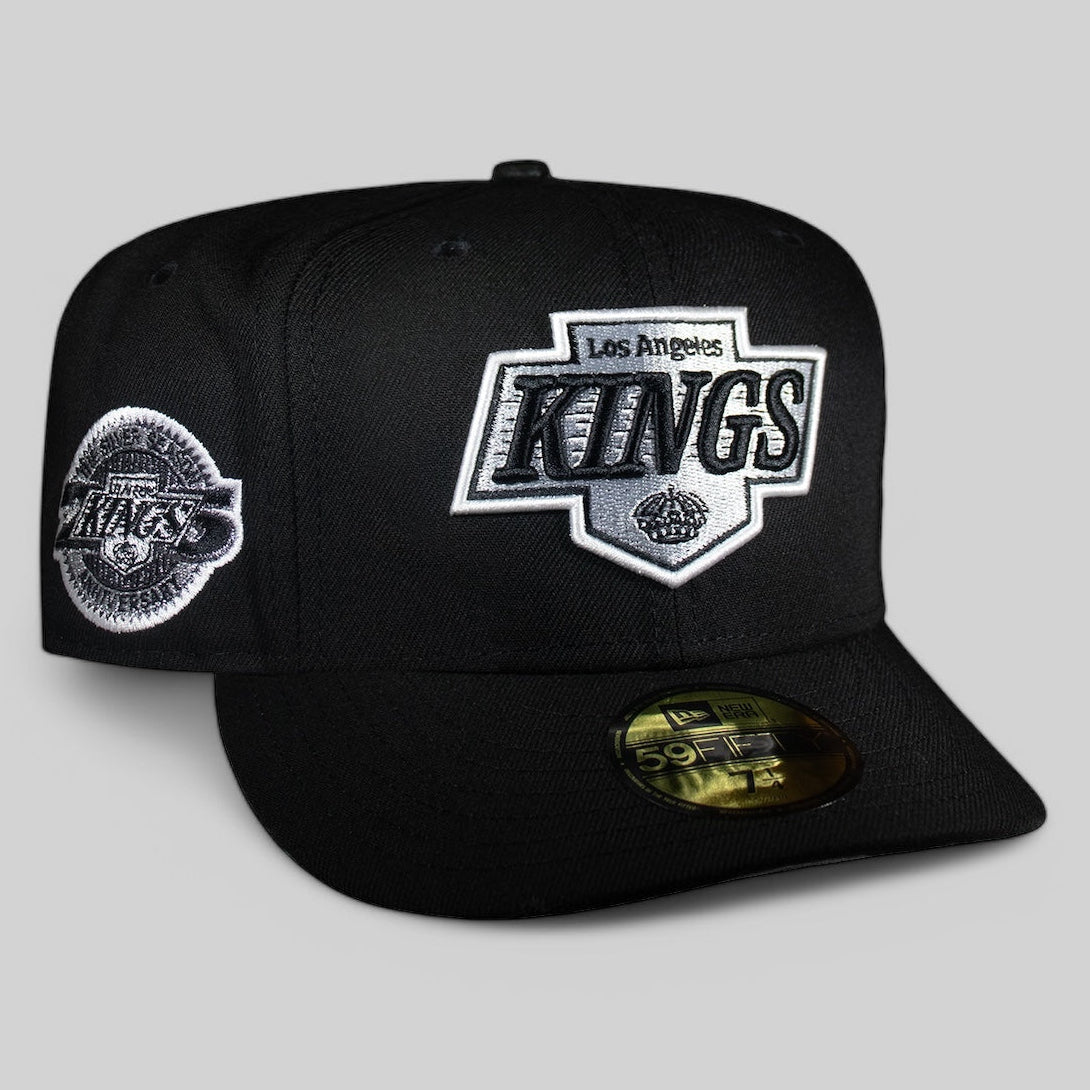A black fitted cap with the Los Angeles Kings NHL team logo in white and gray.