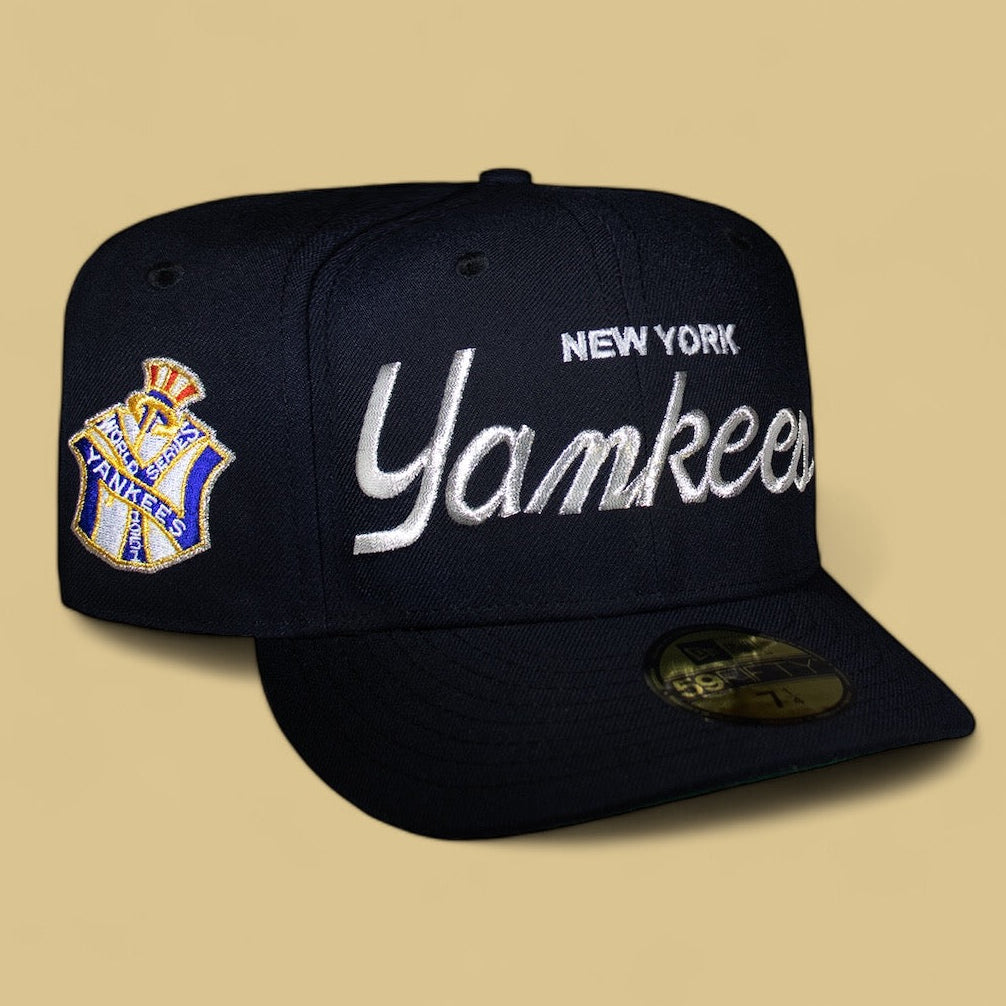 A black New York Yankees baseball cap with the team's name and a logo in Metallic Silver script on the front.